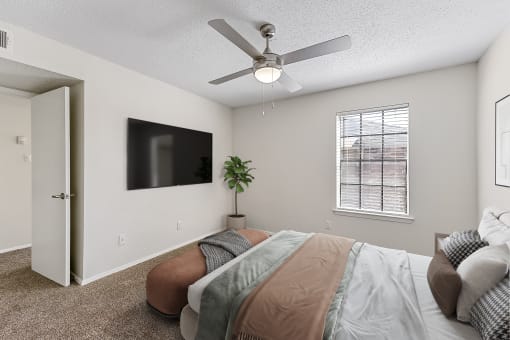 a bedroom with a ceiling fan and a flat screen tv at The Hudson, Texas