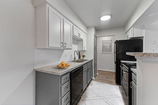 a kitchen with white cabinets and black appliances at The Hills at Ironhorse, North Richland Hills, Texas