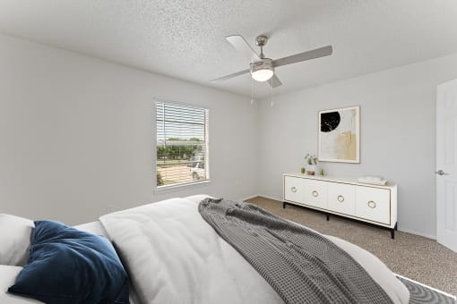 a bedroom with a large bed and a ceiling fan at The Hills at Ironhorse, North Richland Hills