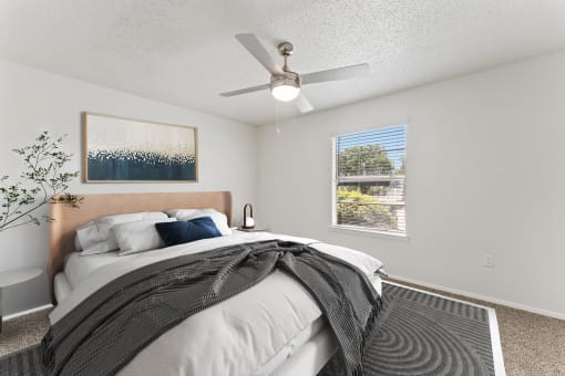 a bedroom with a large bed and a ceiling fan at The Hills at Ironhorse, North Richland Hills, 76180