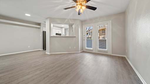 an empty living room with a ceiling fan at Polo Clubs Apartments, Texas