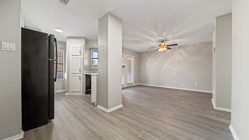 an empty living room and kitchen with a ceiling fan at Polo Clubs Apartments, Austin, 78729