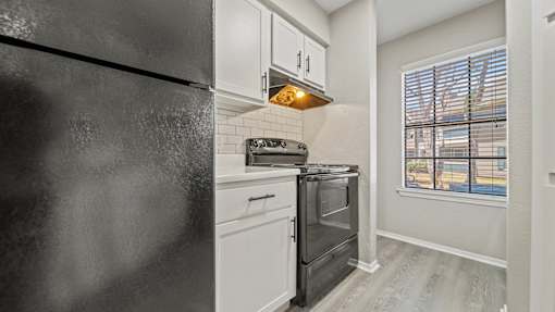 a kitchen with a stove and refrigerator and a window at Polo Clubs Apartments, Texas, 78729