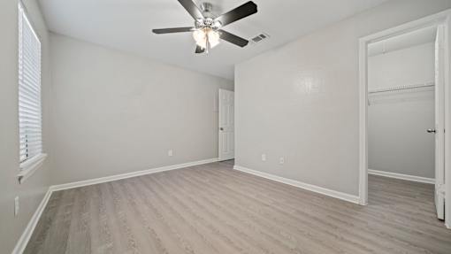 a bedroom with a ceiling fan and a closet at Polo Clubs Apartments, Austin