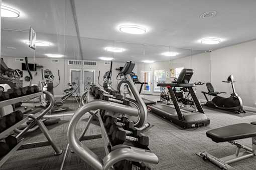 A gym with a variety of exercise equipment including treadmills, stationary bikes, and weight machines. at Preston Bend, Dallas