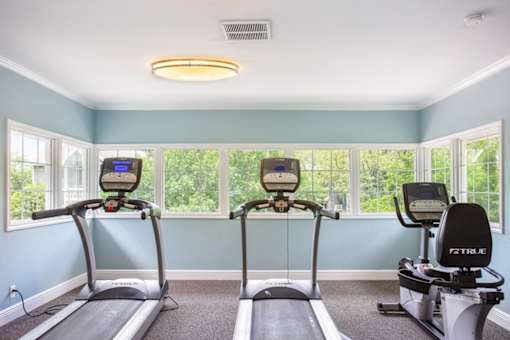 two exercise bikes in a workout room with windows at Polo Clubs Apartments, Texas