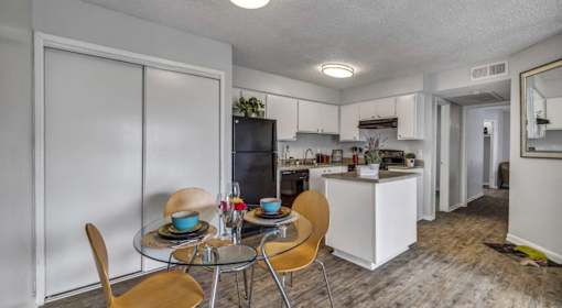 A kitchen with a dining table set for two.