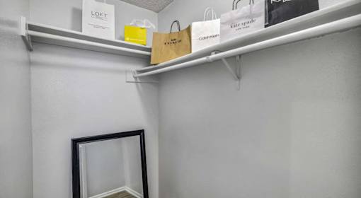 A shelf with a bag and a sign that says Kate Spade.