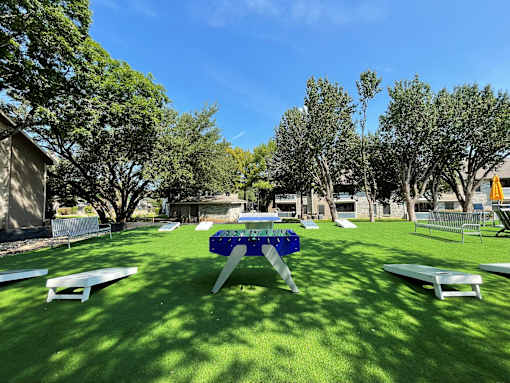 a picnic table in a yard with benches and picnic tables at Polo Clubs Apartments, Texas