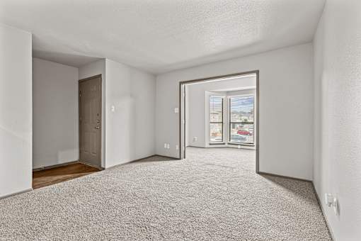A white room with a carpeted floor and a door on the left side.at Rock 35, Texas, 78681
