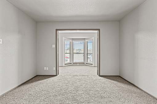 A room with a carpeted floor and a doorway leading to a balcony.at Rock 35, Round Rock, Texas