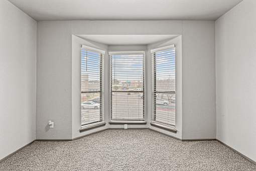 A room with a carpeted floor and a window with blinds.at Rock 35, Texas