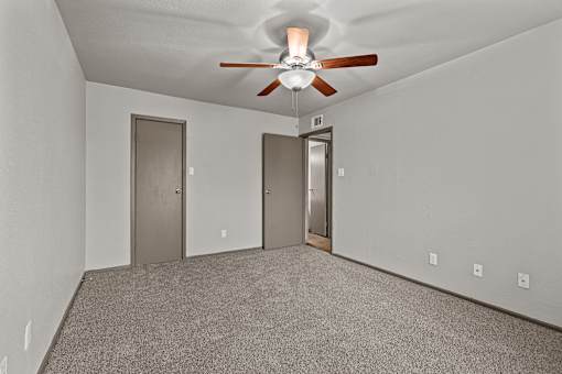 A room with a ceiling fan and two doors.at Rock 35, Round Rock, 78681