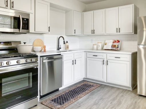 a kitchen with white cabinets and stainless steel appliances  at Sunset Heights, San Antonio, 78209