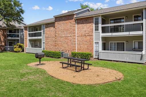 A brick building with a picnic table in front of it.