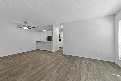 an empty living room with a ceiling fan  at Vesper, Dallas, 75254