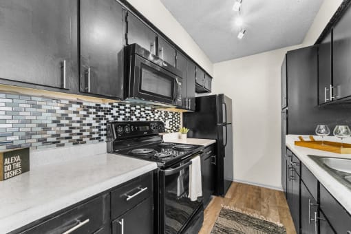 a kitchen with black cabinets and white countertops at Vesper, Dallas, 75254