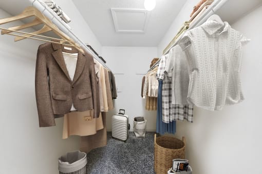 a walk in closet with clothes hanging on a rack and a toilet in the corner  at Vesper, Dallas, 75254