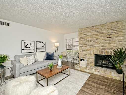 a living room with a couch and a fireplace at Peaks at Northwest Hills Apartments, Austin, 78731