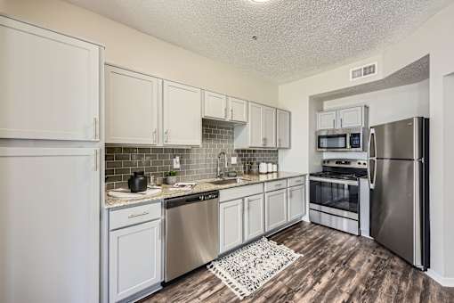 A kitchen with white cabinets and stainless steel appliances.