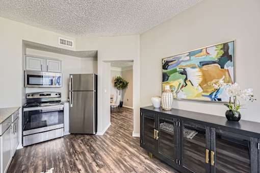 A kitchen with a refrigerator, oven, and cabinets.