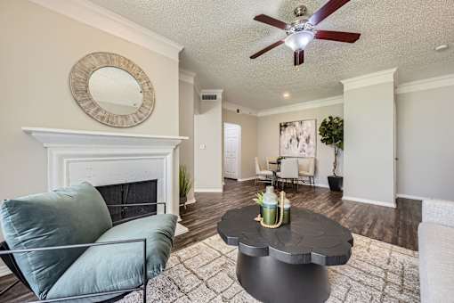 A living room with a fireplace, a chair, and a coffee table.
