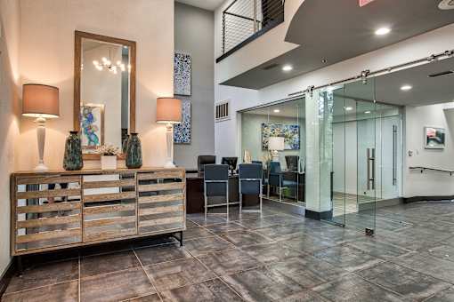 A room with a wooden reception desk and a glass door.