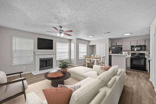 A living room with a white couch and a fireplace.