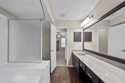 A bathroom with a white tub and sink.