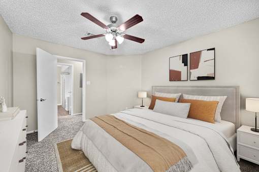 A bedroom with a large bed and a ceiling fan.