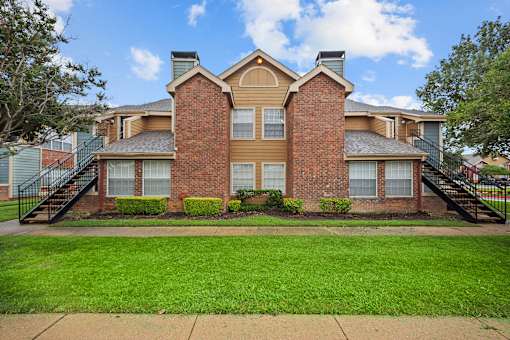 A brick house with a green lawn in front.