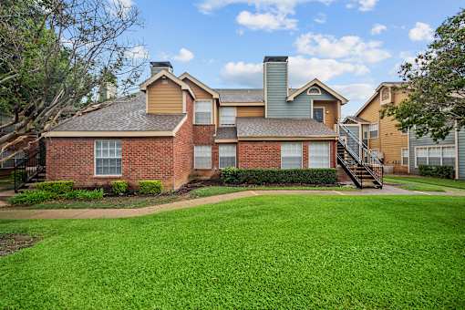 A large house with a green lawn in front.