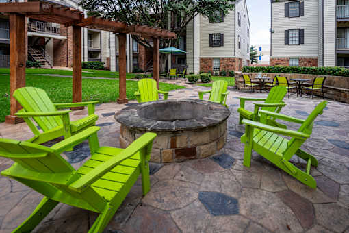 Green chairs and table around a fire pit.