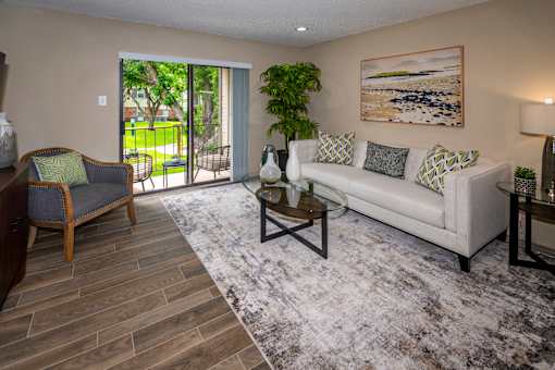 A living room with a couch, chair, and a painting on the wall.