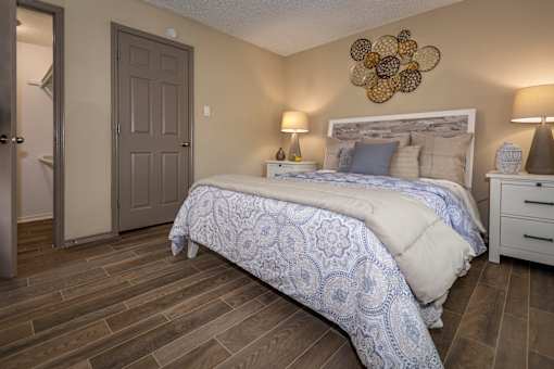 A bedroom with a bed, nightstand, and lamp.