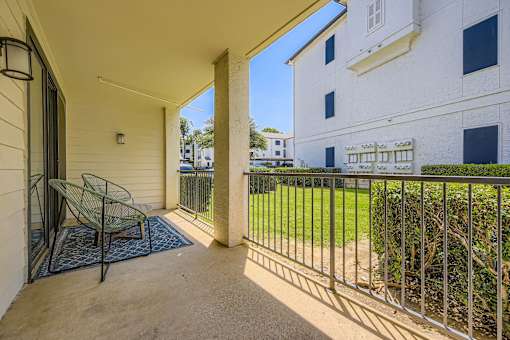 A balcony with a chair and a table.