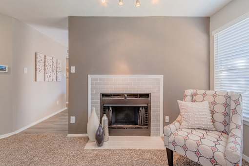 A living room with a fireplace and a chair.
