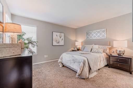 A bedroom with a large bed and a dresser.