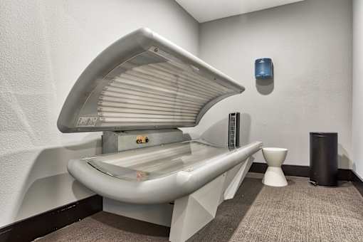 A modern bathroom with a white toilet and a trash can.