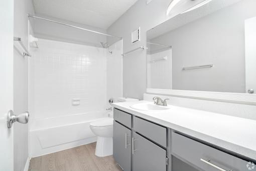 A white bathroom with a toilet, sink, and bathtub.