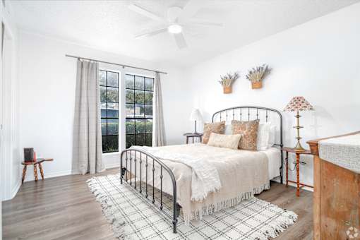 A bedroom with a bed, a chair, and a window with curtains.