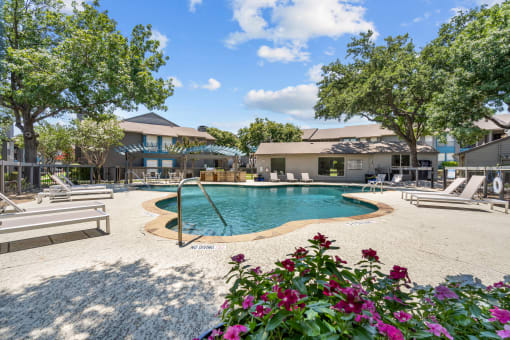 a pool with lounge chairs and trees in the background  at Vesper, Texas