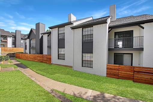 A row of modern houses with white walls and dark roofs.