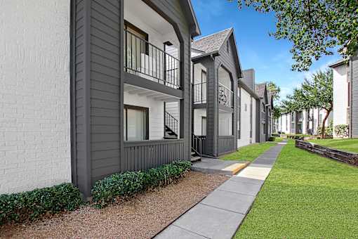 A row of modern townhouses with balconies and greenery.