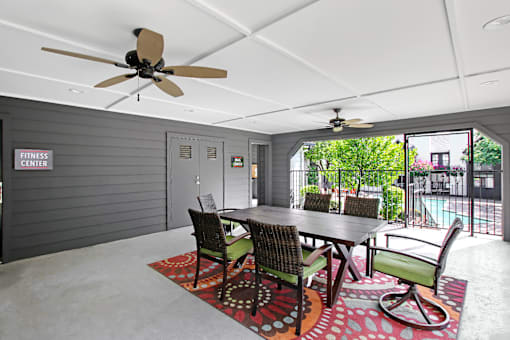 A dining room with a table and chairs and a ceiling fan.