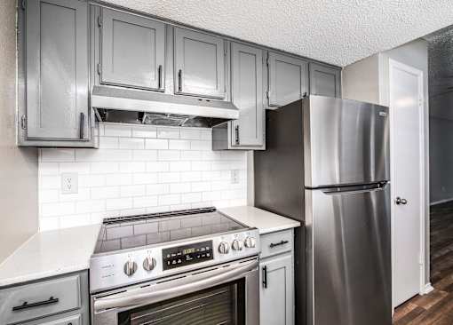A kitchen with a stove, oven, and refrigerator.