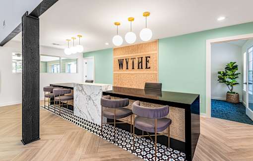 A reception area with a marble counter and chairs.
