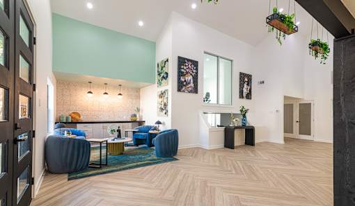 A living room with a blue couch and a wooden floor.