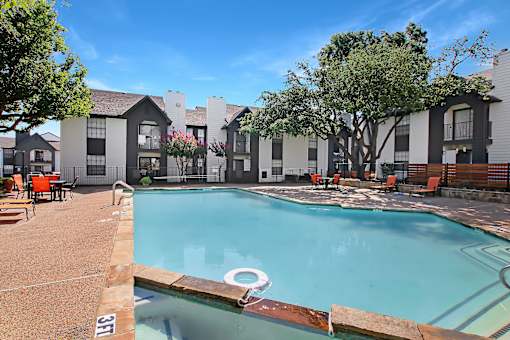 A swimming pool with a diving board in front of a building.