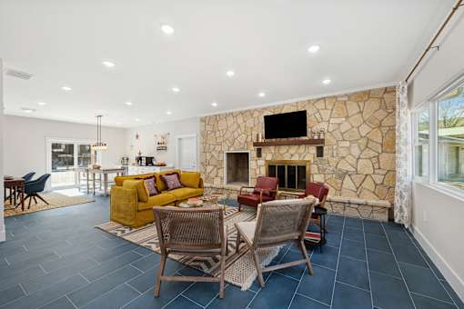 living room with a stone fireplace at Crosspoint Oaks at Boerne, Texas
